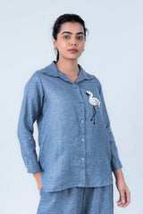Blue linen shirt with flamingo embroidery, paired with matching pants for casual comfort.