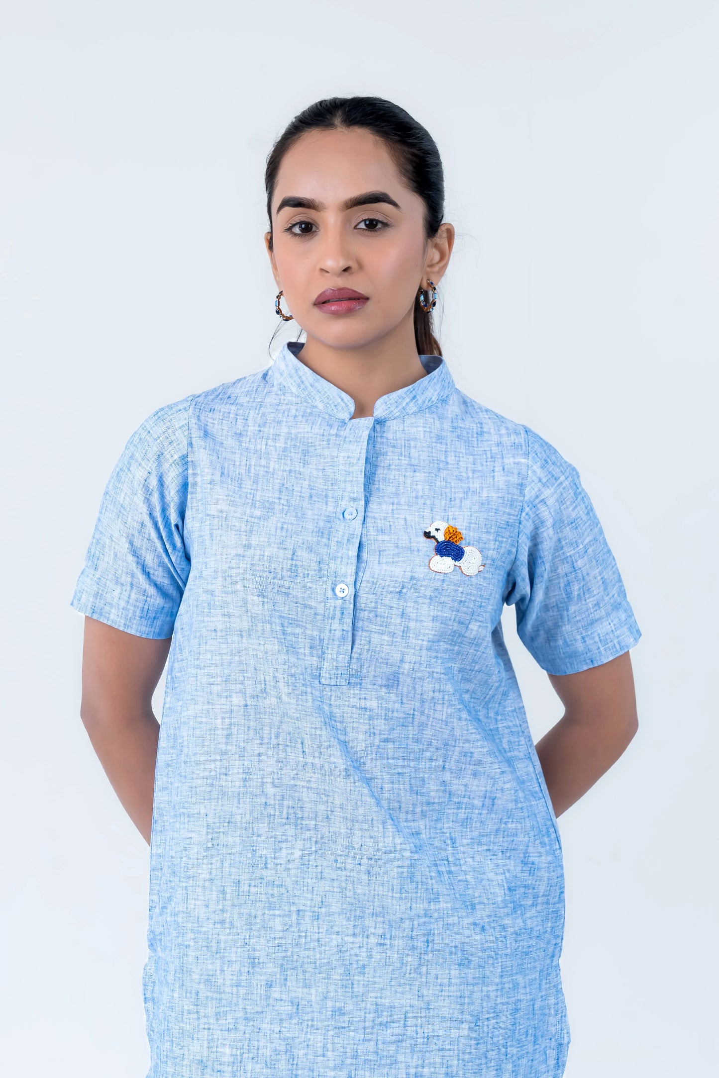 Light blue textured dress with embroidered dog design, short sleeves, and button front