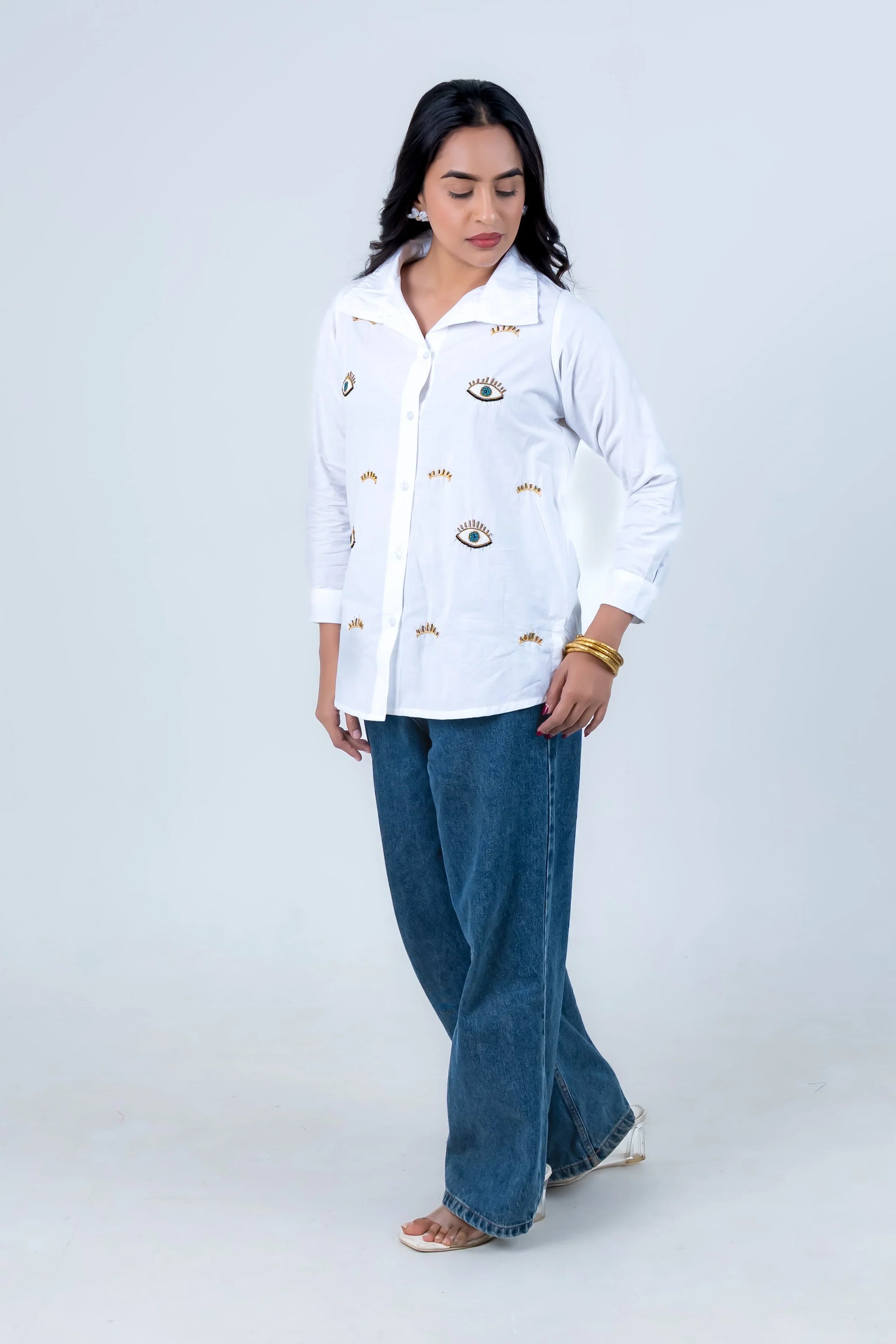 White embroidered eye-pattern shirt with wide-leg jeans for trendy women's fashion