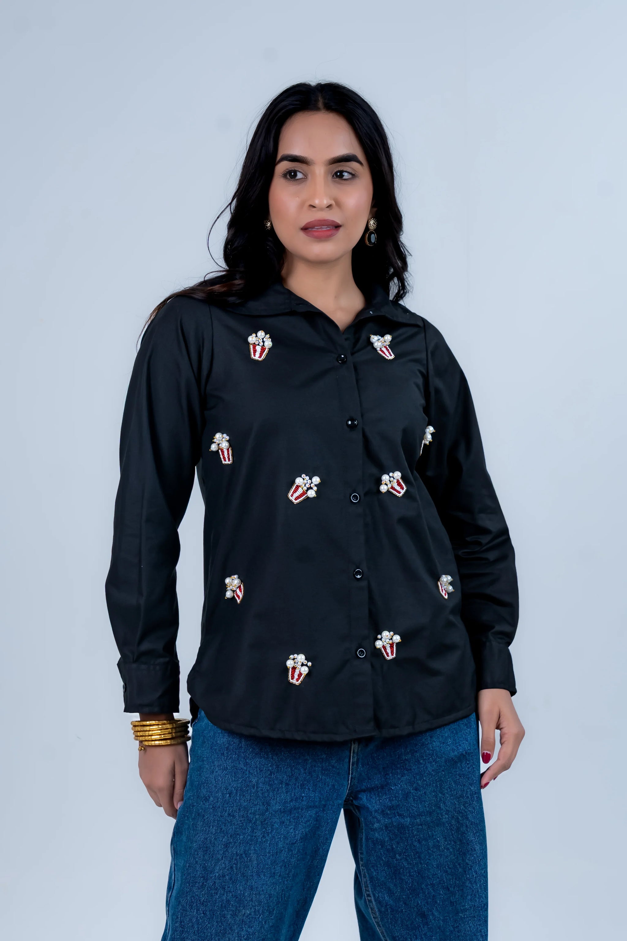 Black shirt with popcorn embroidery, paired with blue jeans, stylish women's fashion
