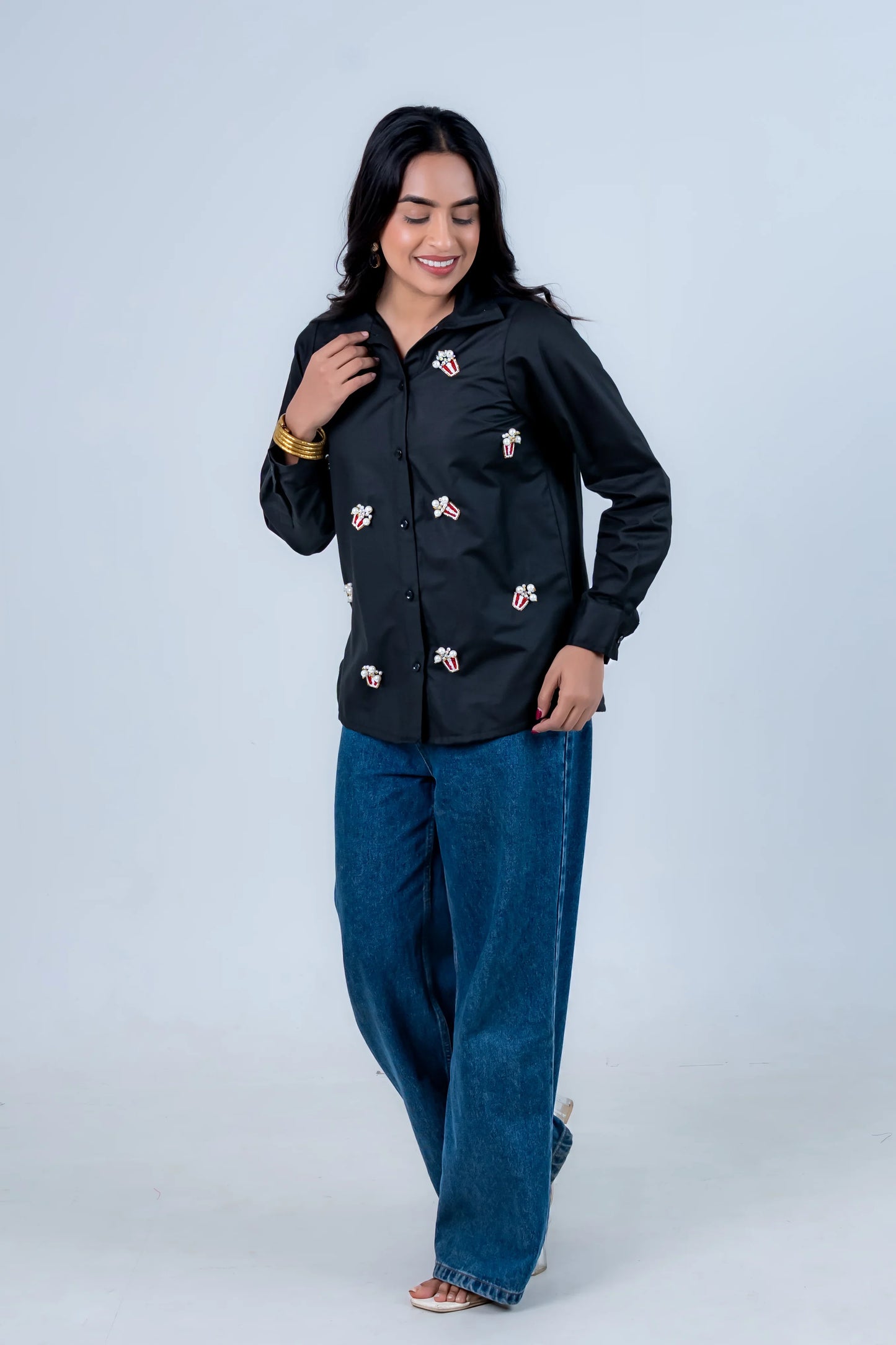 Black shirt with popcorn embroidery paired with wide-leg jeans for trendy everyday style