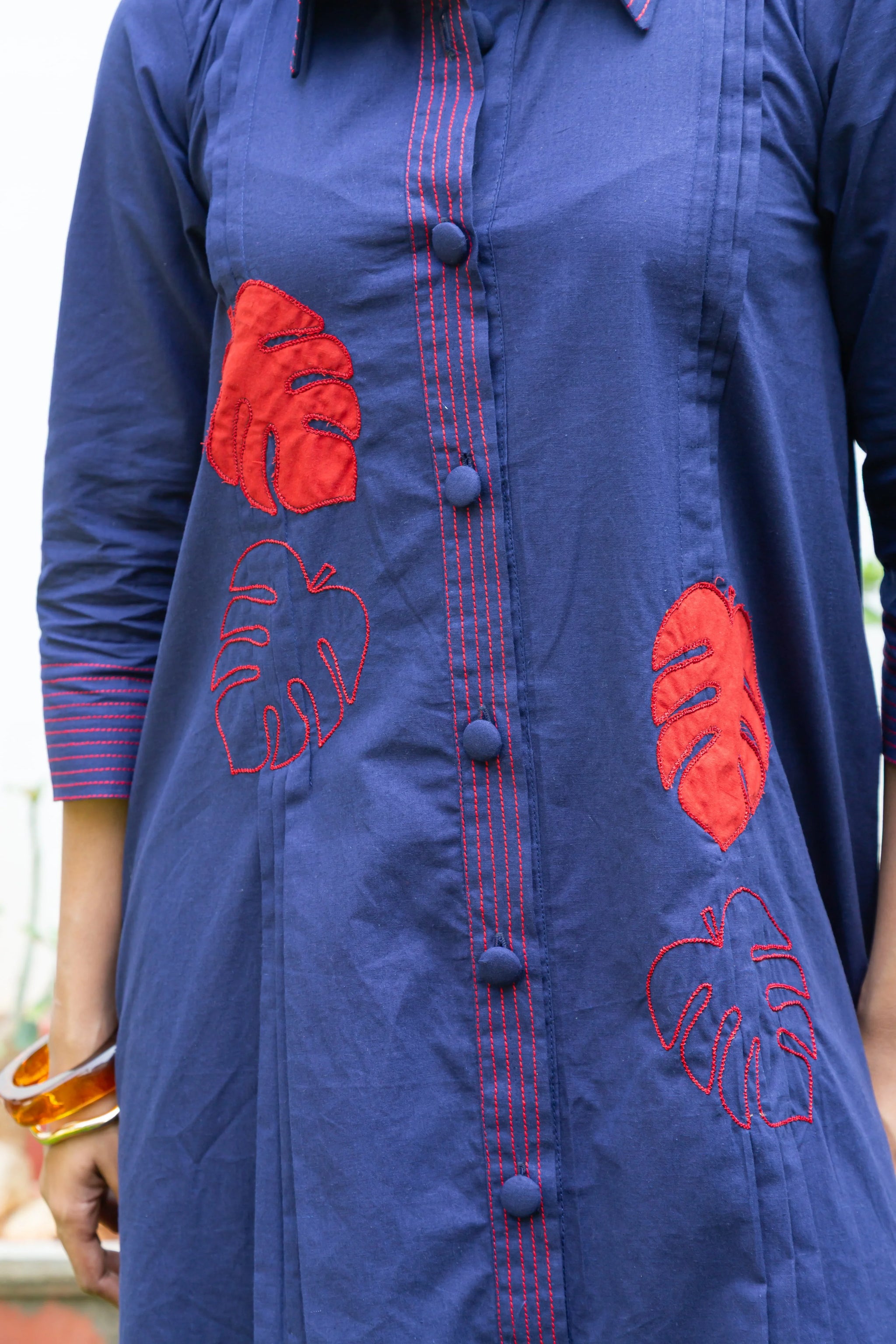 Navy blue dress with red leaf embroidery and button front design