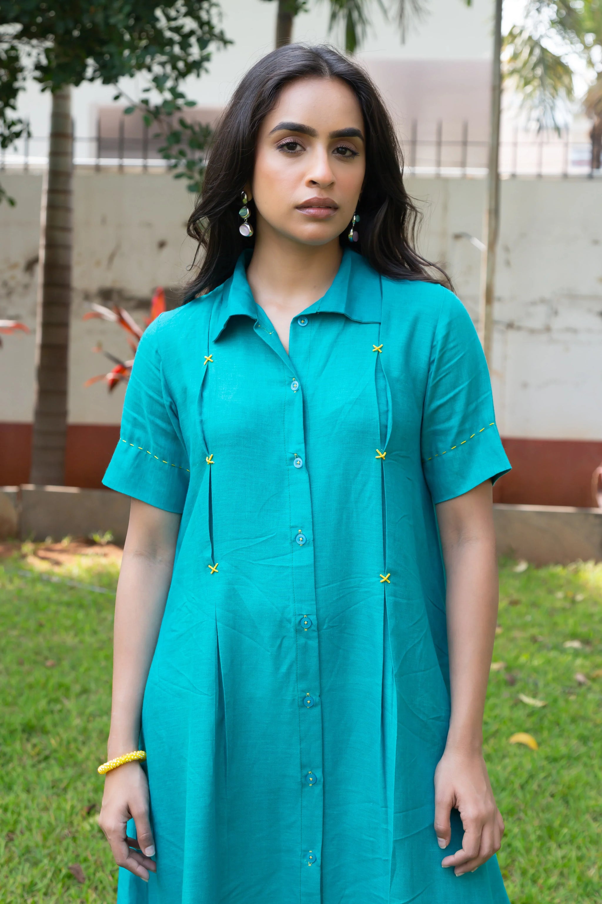 Teal button-down dress with yellow embroidery, perfect for everyday wear and comfort.