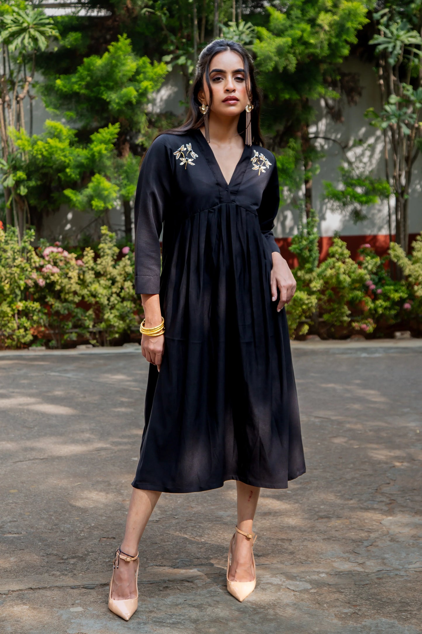 Black midi dress with dragonfly embroidery, V-neck, 3/4 sleeves, paired with beige heels and gold jewelry
