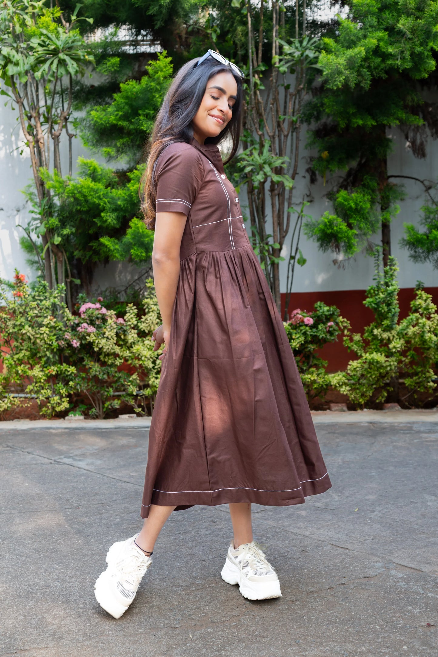 Brown midi dress with white stitching, paired with white sneakers, perfect for casual everyday wear.