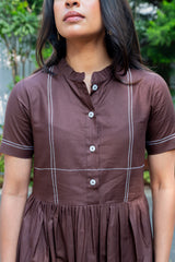 Brown button-front dress with white contrast stitching, short sleeves, and pleated skirt for women