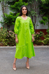 Vibrant green midi dress with pearl embellishments and puff sleeves, paired with beige heels