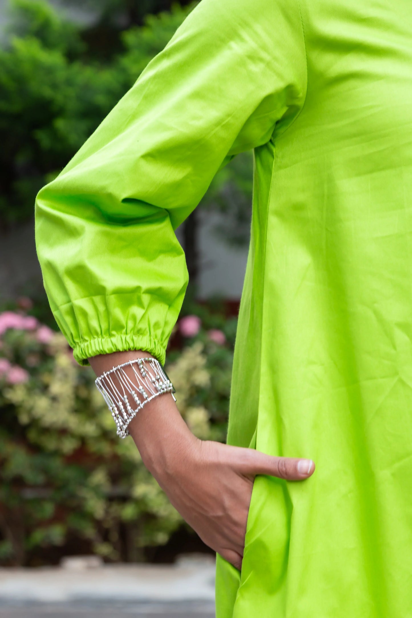 Vibrant lime green dress with puffed sleeves and silver beaded bracelet