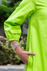 Vibrant lime green dress with puffed sleeves and silver beaded bracelet