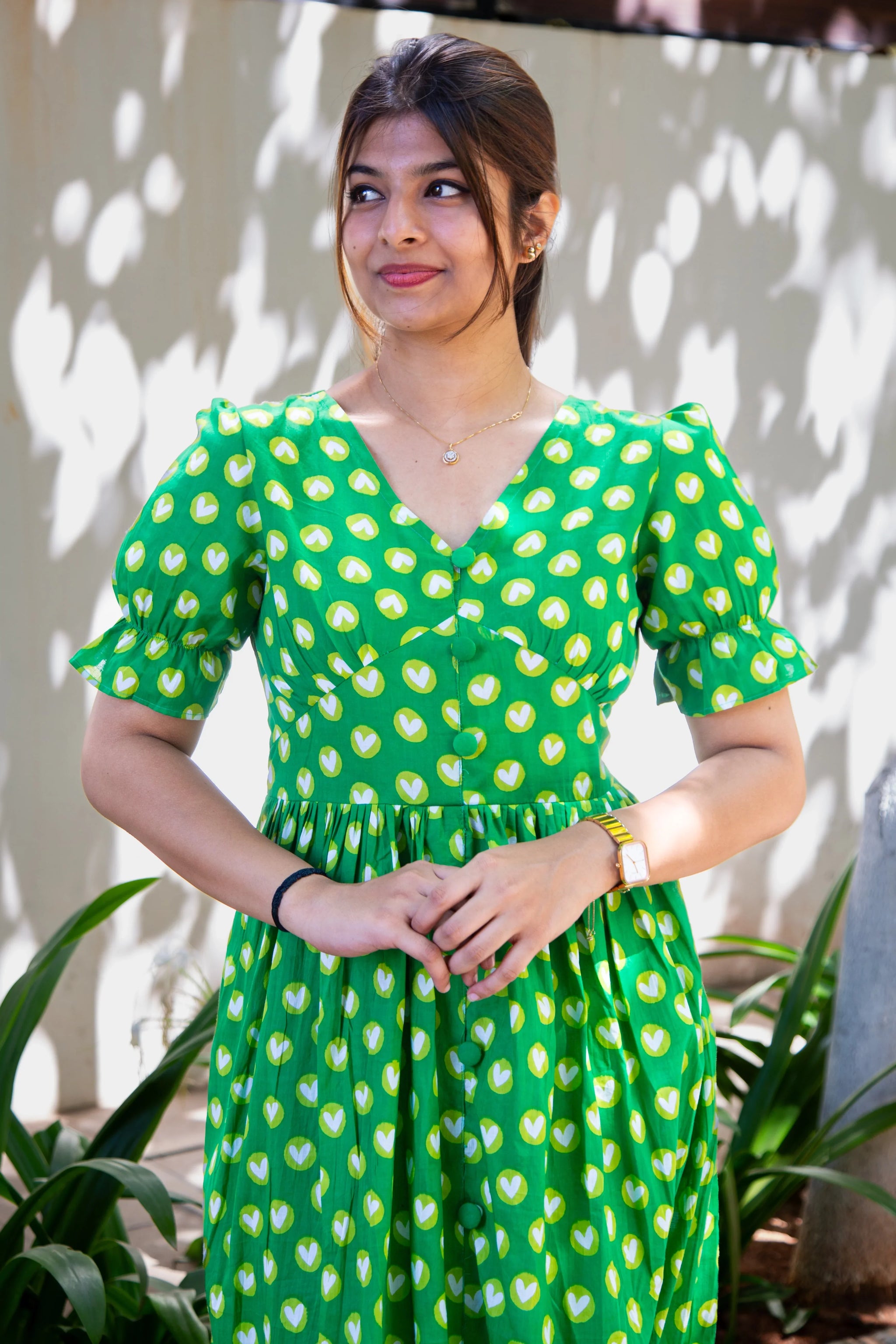 Green heart print dress with puff sleeves, V-neck, and button front, perfect for everyday wear.
