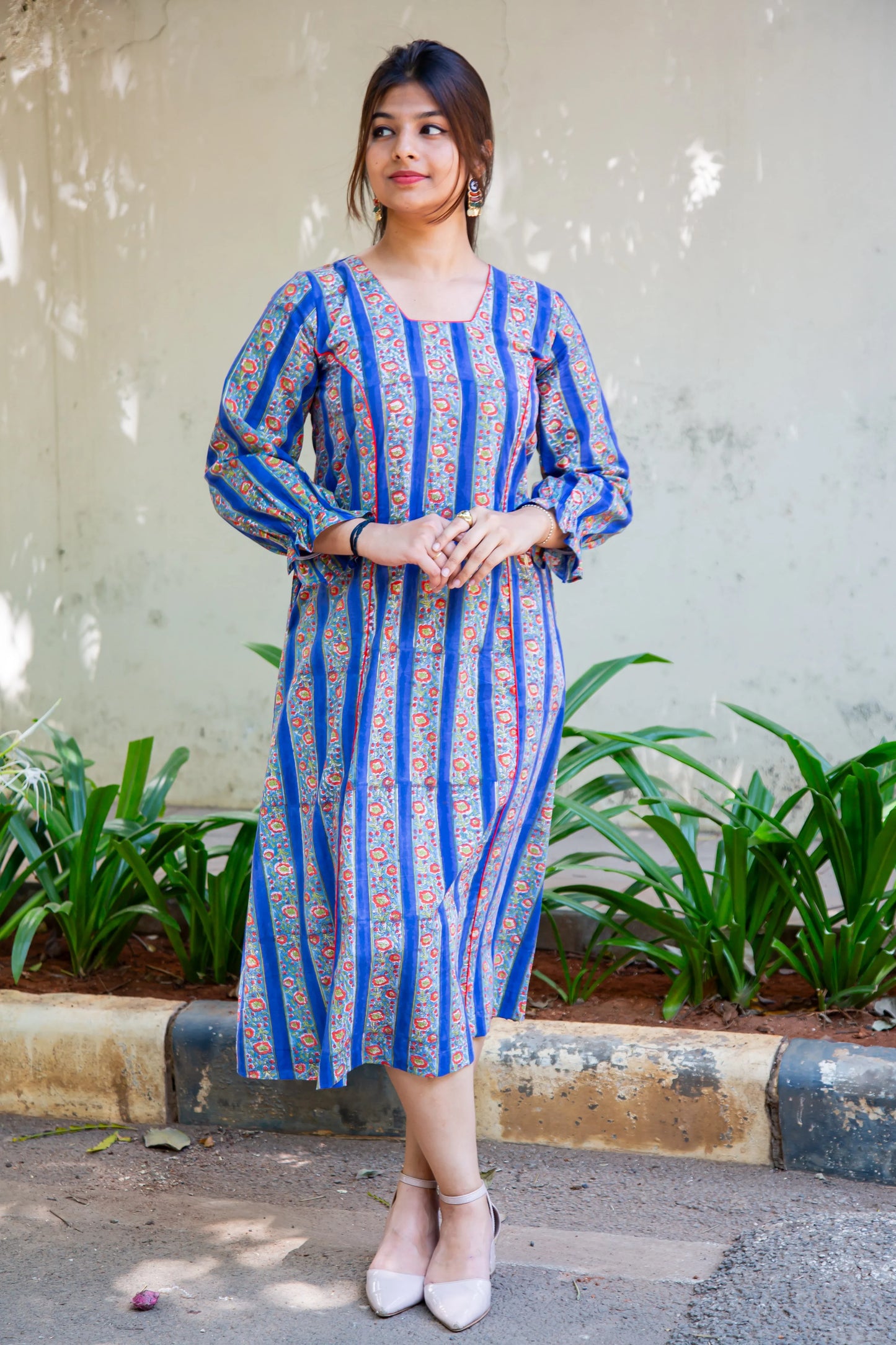 Blue striped floral dress with long sleeves, paired with beige heels, perfect for everyday wear.