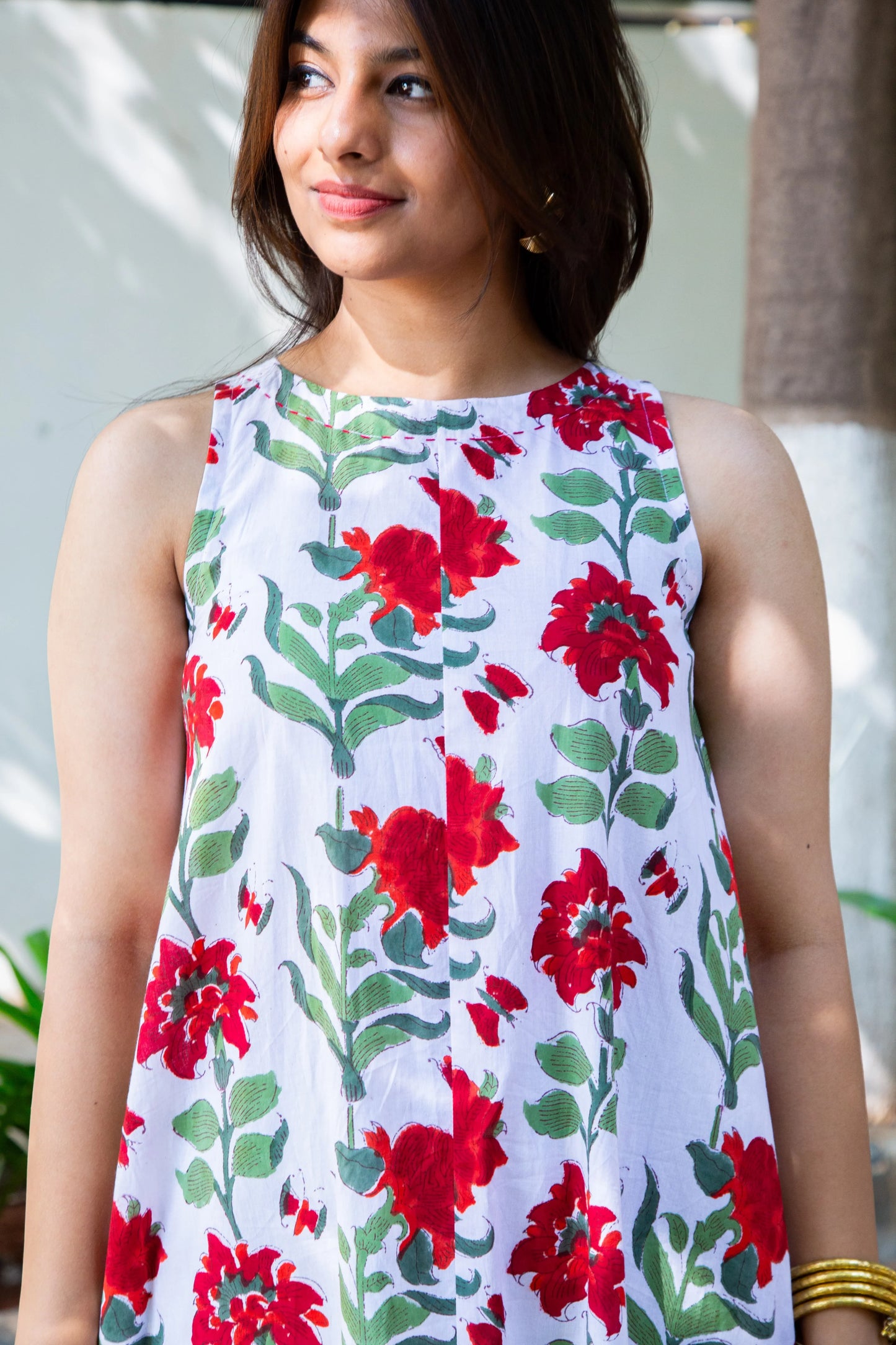White sleeveless dress with red floral print and green leaves, perfect for everyday wear