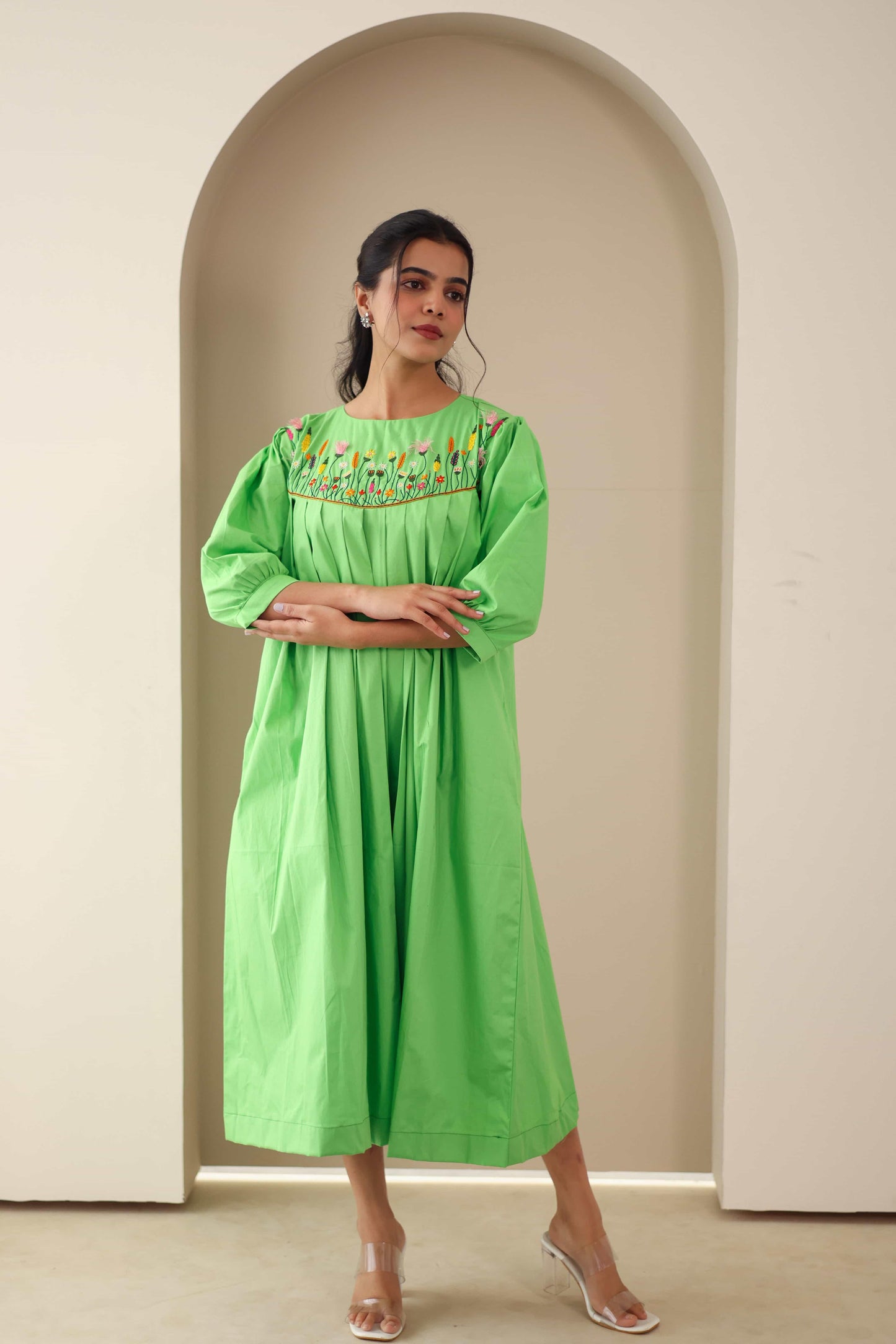 Woman wearing a green embroidered cotton poplin dress with floral detailing and three-quarter sleeves