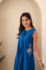 Woman wearing navy blue embroidered cotton dress with floral flamingo motif