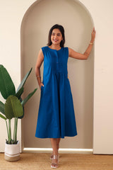 Woman wearing sleeveless navy blue embroidered cotton midi dress with pleated front