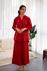Woman in red embroidered cotton co-ord set with wide-leg pants and long top indoors